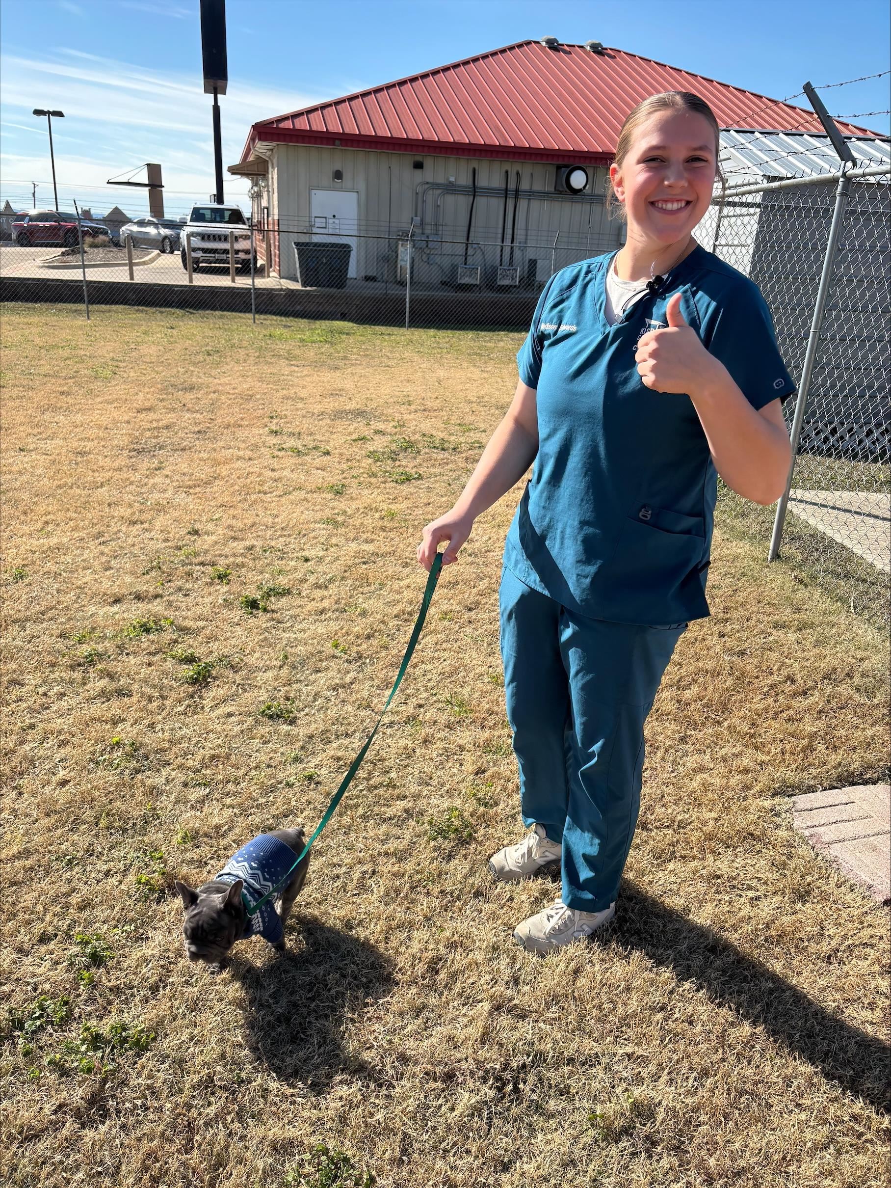 student holding leash with dog